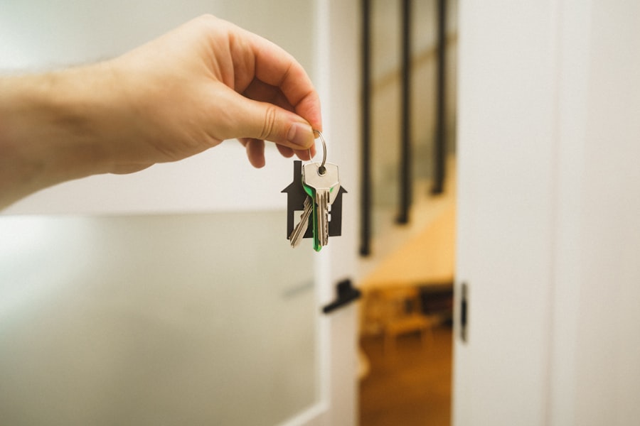 A hand holding new house keys at an open front door