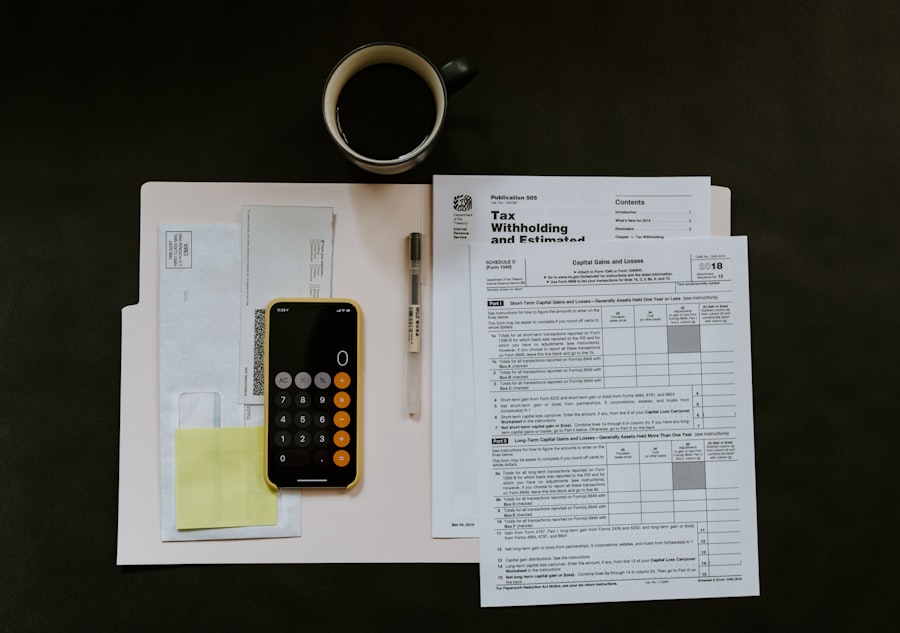 Tax forms, a calculator, and coffee on a dark desk
