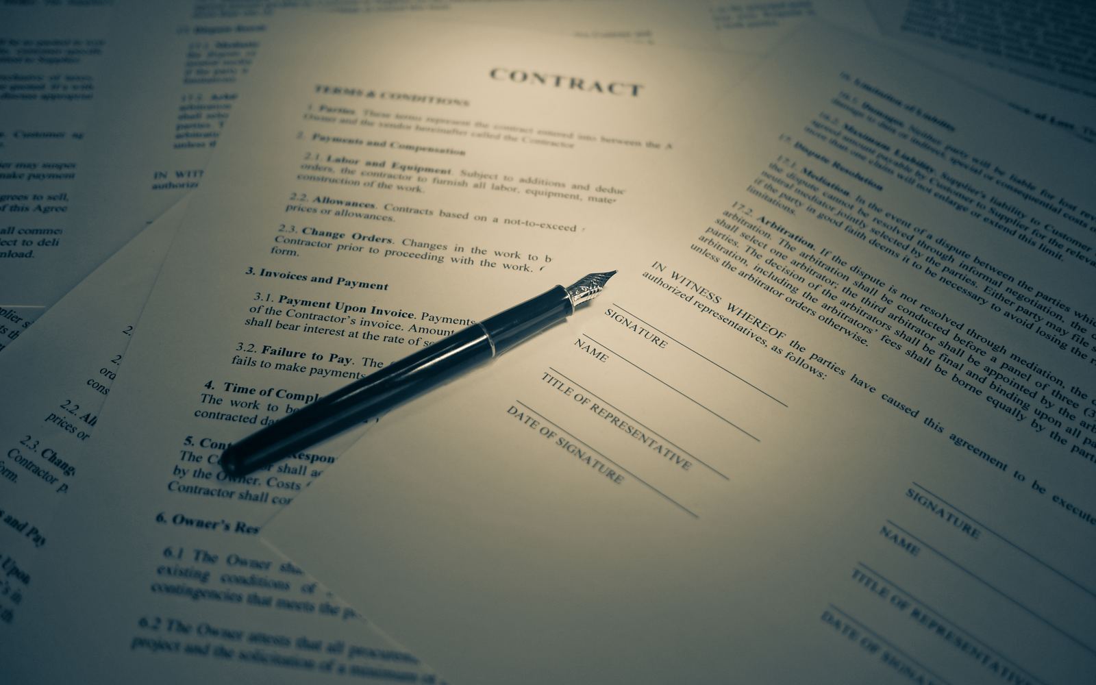 A fountain pen resting on a contract open to its signature lines