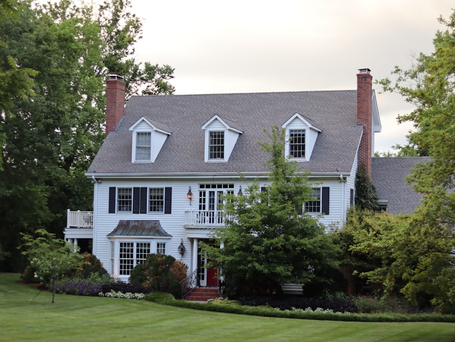 A white colonial home with a red front door on a manicured Long Island lawn